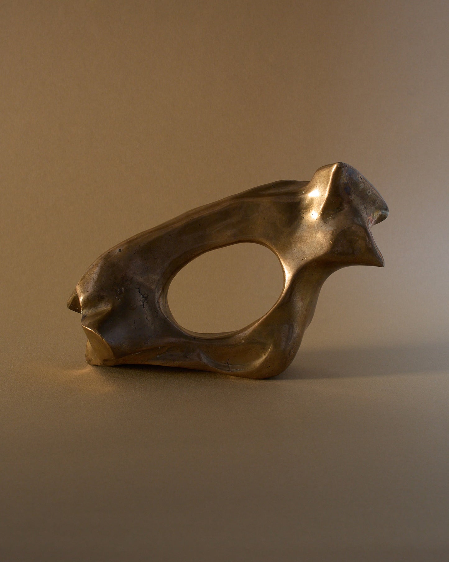 Bronze sculpture by James Mercurin (c.1990s) — undulating abstract form, viewed from the left.