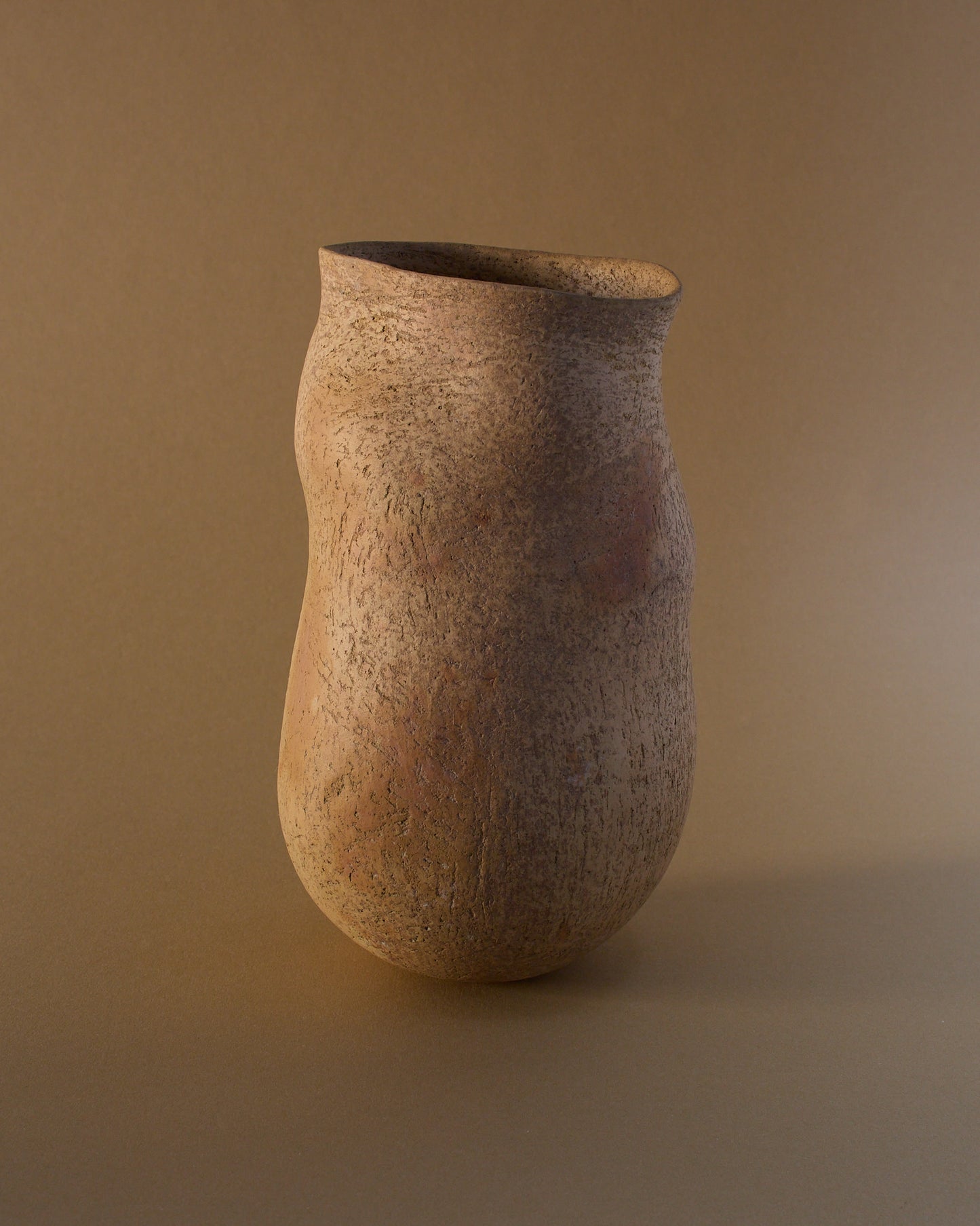 Front view of ceramic vase by Elspeth Owen (c.2000s) — organic silhouette, smoke-fired surface in sand tones.
