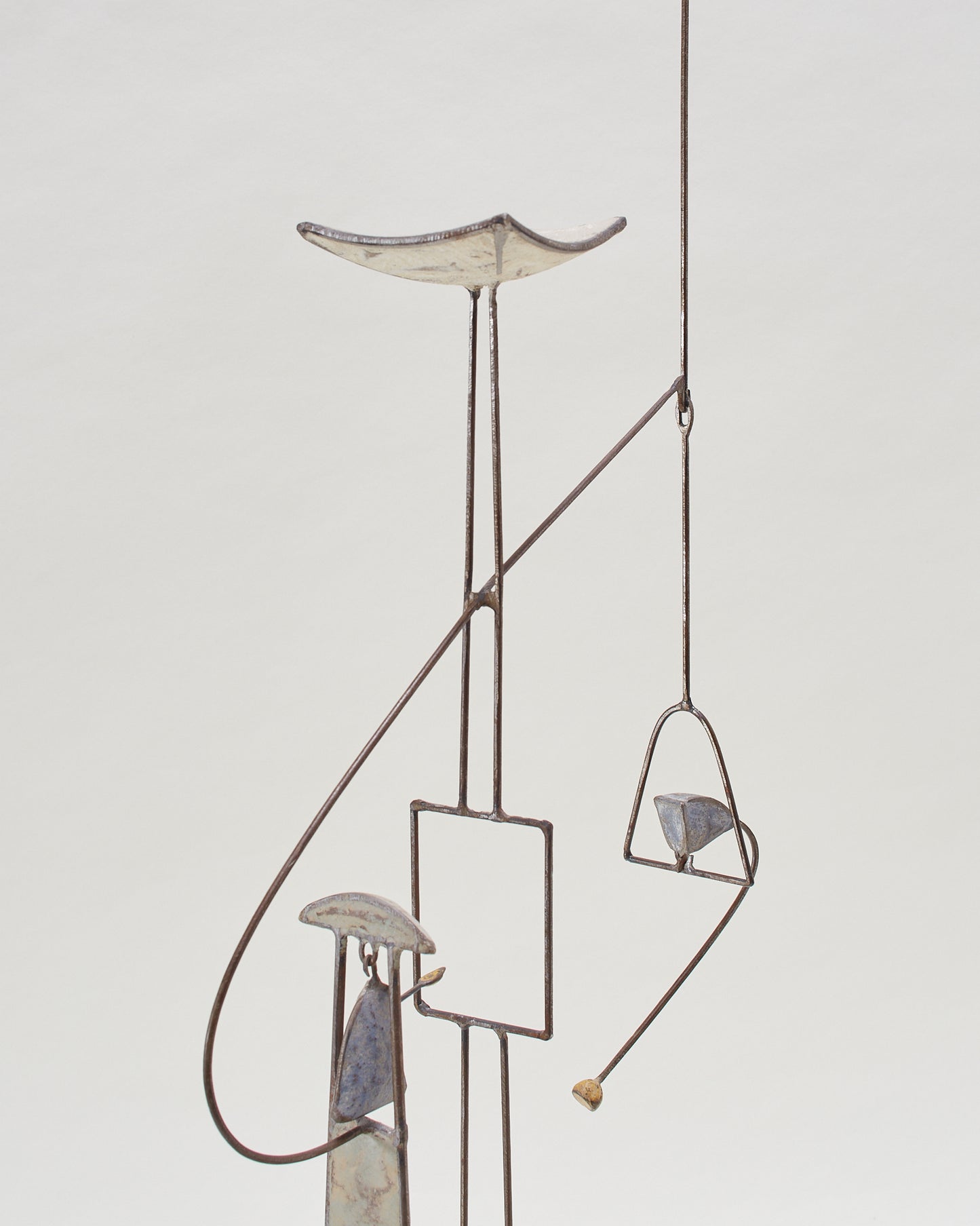 A close up detail shot of the kinetic abstract sculpture (20th century) by Thierry Dufourmantelle, featuring four moving parts, constructed from steel and concrete with pastel yellow, turquoise, and blue pigments.