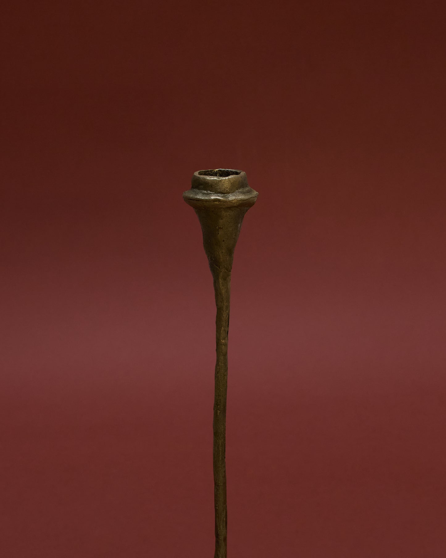 Detail view of tall bronze candle holder (1980) by German sculptor Walter Kaune, featuring a sculptural design with a textured finish.