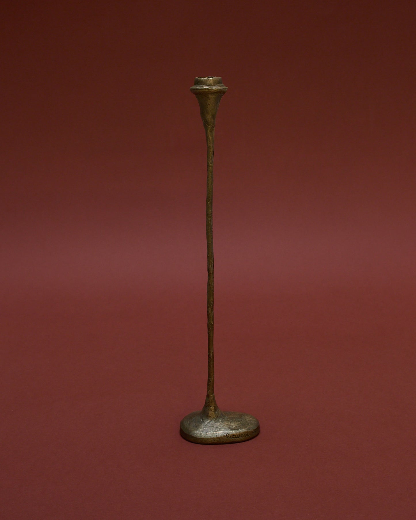Side angle view of tall bronze candle holder (1980) by German sculptor Walter Kaune, featuring a sculptural design with a textured finish.