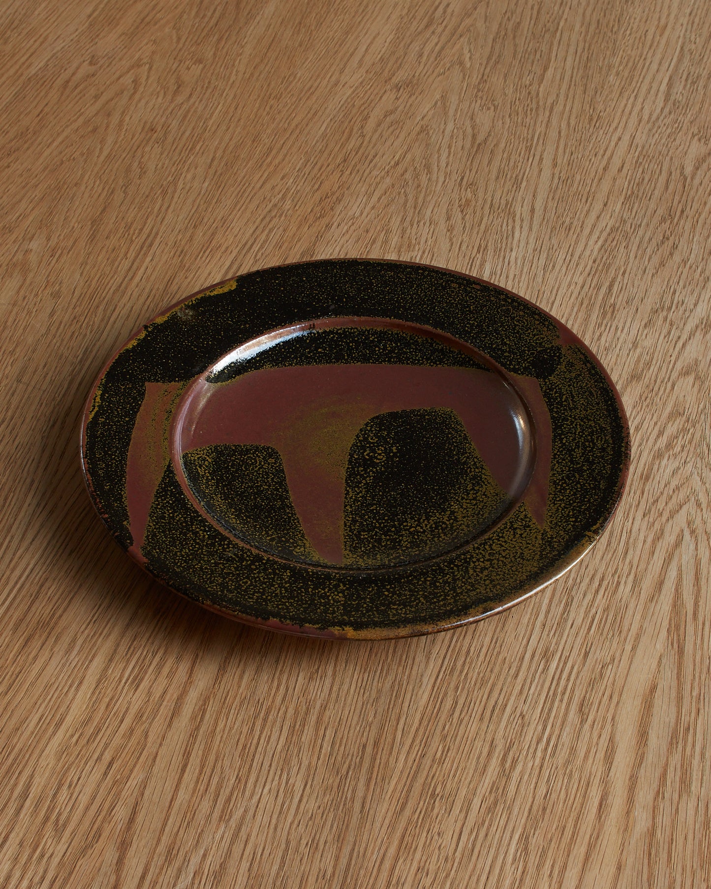 Ray Finch tenmoku glaze plate, top view. Category — Decorative Plates & Studio Pottery