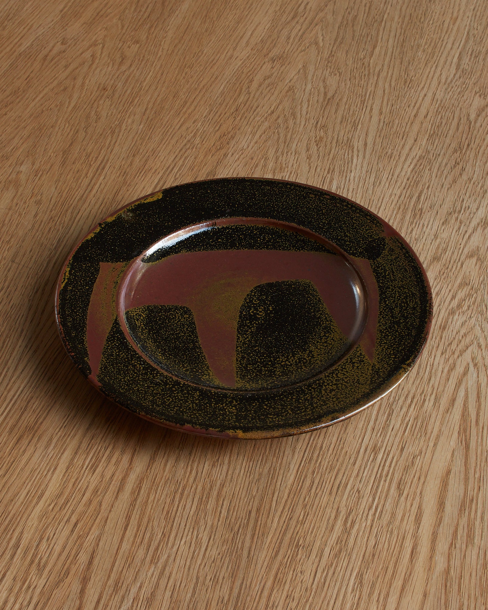 Ray Finch tenmoku glaze plate, top view. Category — Decorative Plates & Studio Pottery